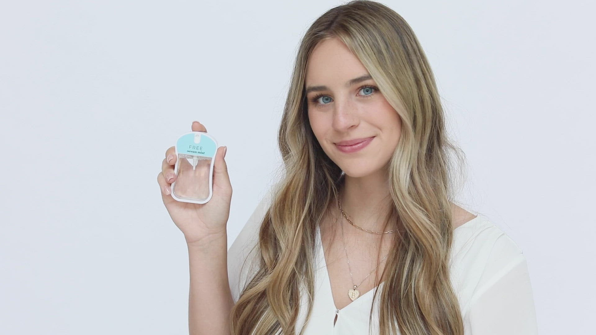 Free (Ocean mist) Moisturizing Body Mist in light blue color box and rounded rectangle spray bottle with light blue color label and clear liquid. Spray bottle has 1.1 fl oz or 35 mL. Spray bottle pictured with model holding spray bottle in her hand and spraying then smiling.