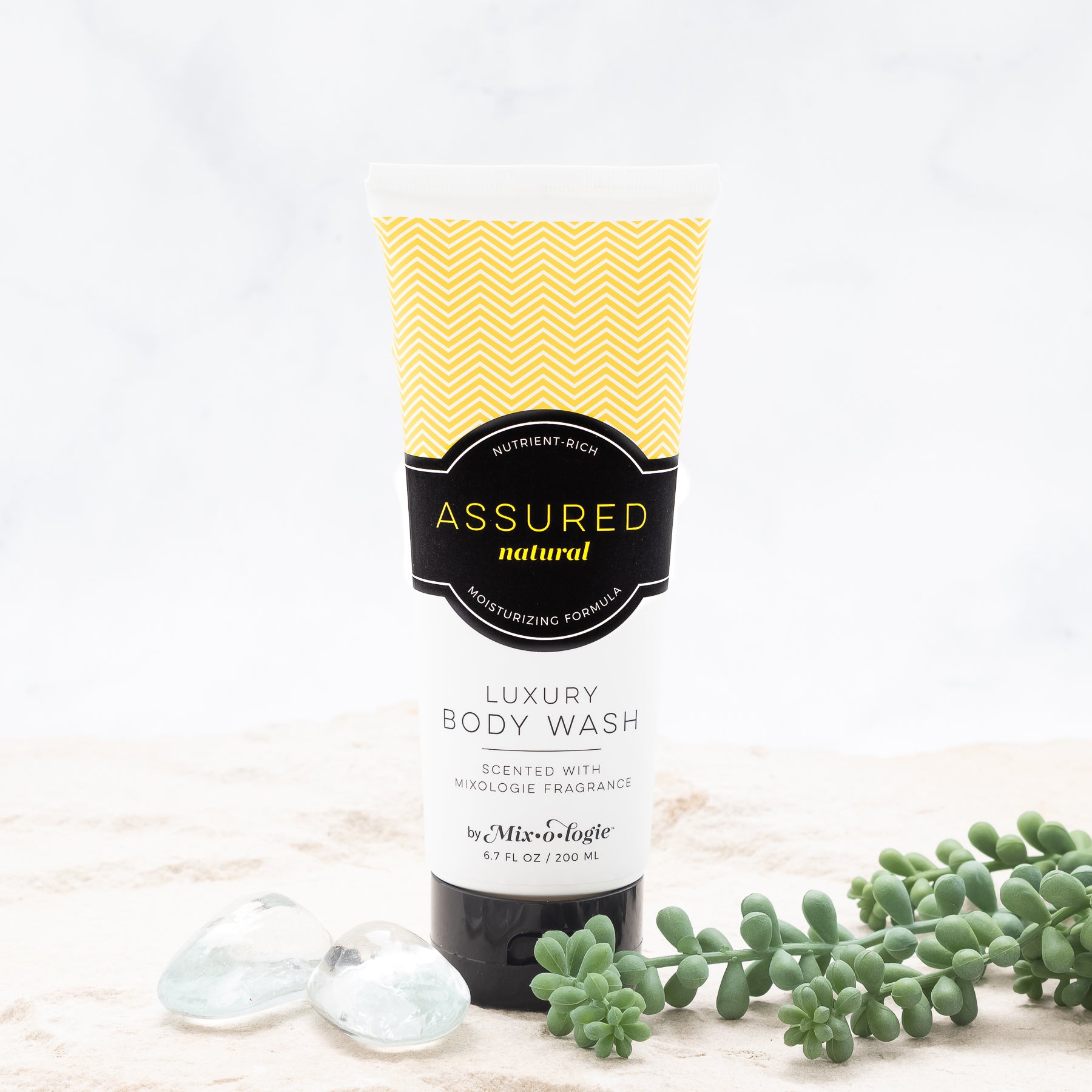 Luxury Body Wash in Mixologie’s Assured (Natural) in yellow color sample package with black label. Contains 6.7 fl oz or 200 mL pictured on a white background. 