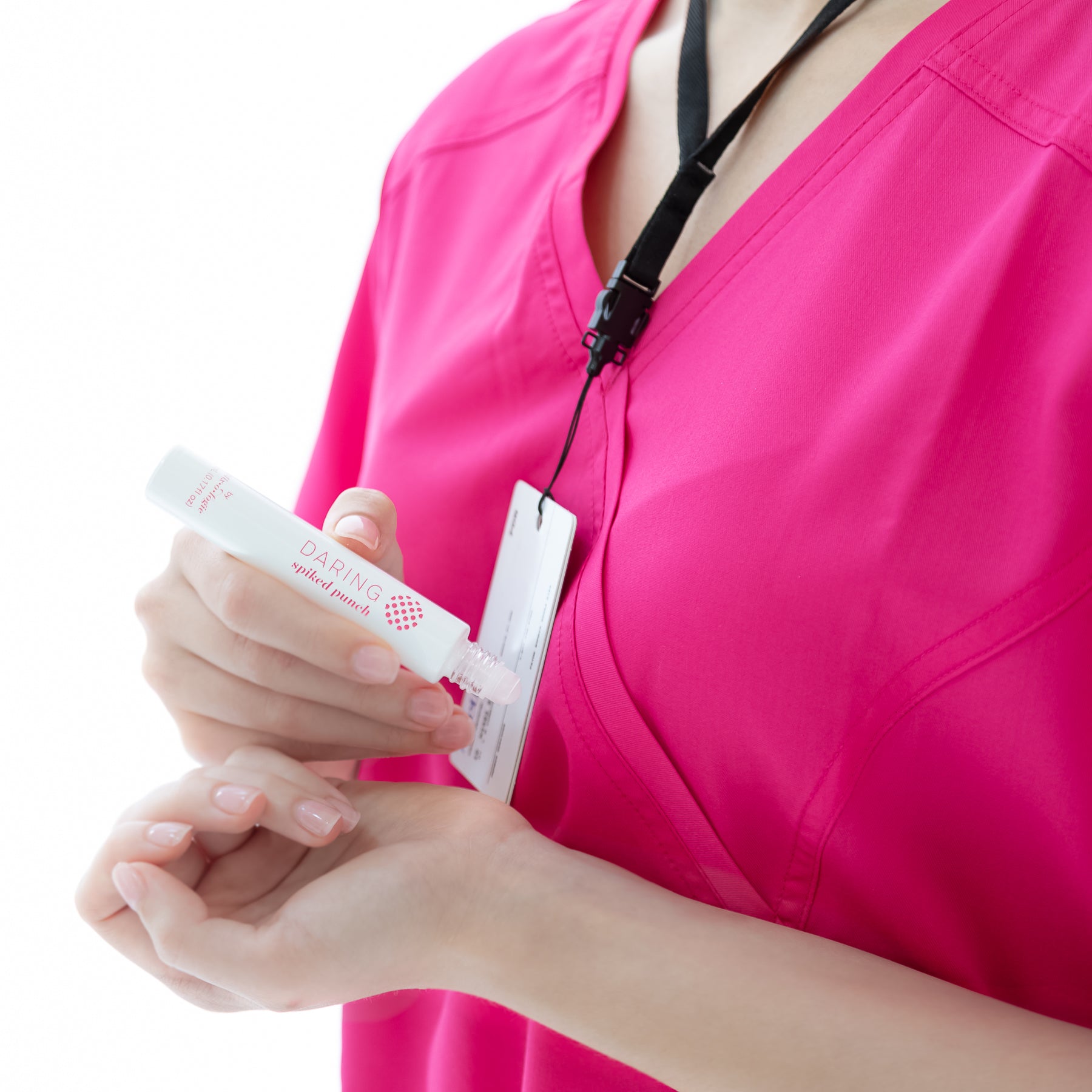 Daring (Spiked Punch) white cylinder rollerball with bright pink color lettering with black box and bright pink color lettering. Rollerball has 0.17 fl oz or 5 mL. Rollerball and rollerball box pictured being applied to nurses wrist.