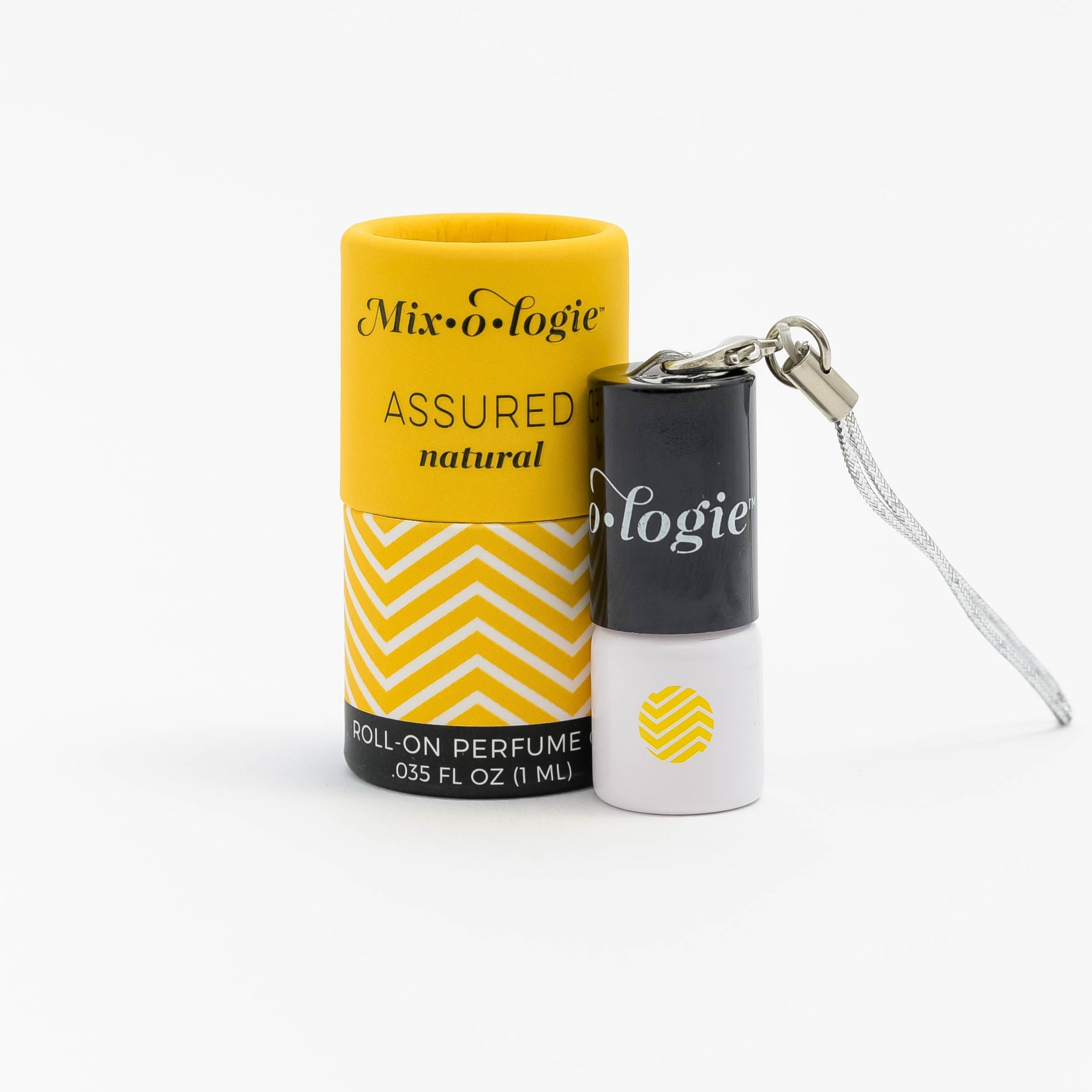 Assured (Natural) mini white cylinder rollerballs with black top and keychain attachment with mustard chevron pattern has .035 fl oz or 1 mL. Mustard cylinder packing tube with mustard chevron pattern. Roll-on perfume oil. Mini rollerball and cylinder tube pictured with a white background