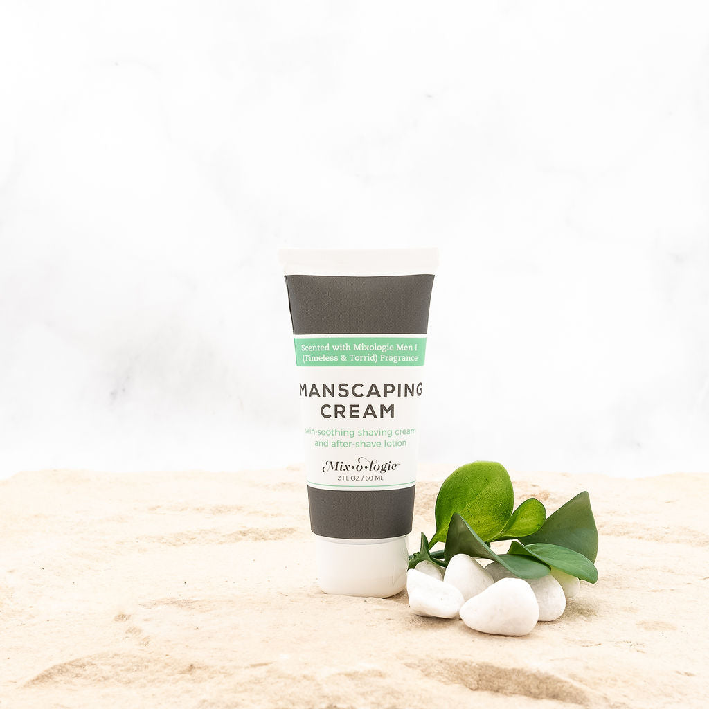 Men’s Manscaping Cream in Men’s I (Timeless & Torrid) in a black and white tube with green accents. Skin-soothing shaving cream and after-shave lotion. 2 fl oz or 60 mL. pictures in sand with rocks and greenery.
