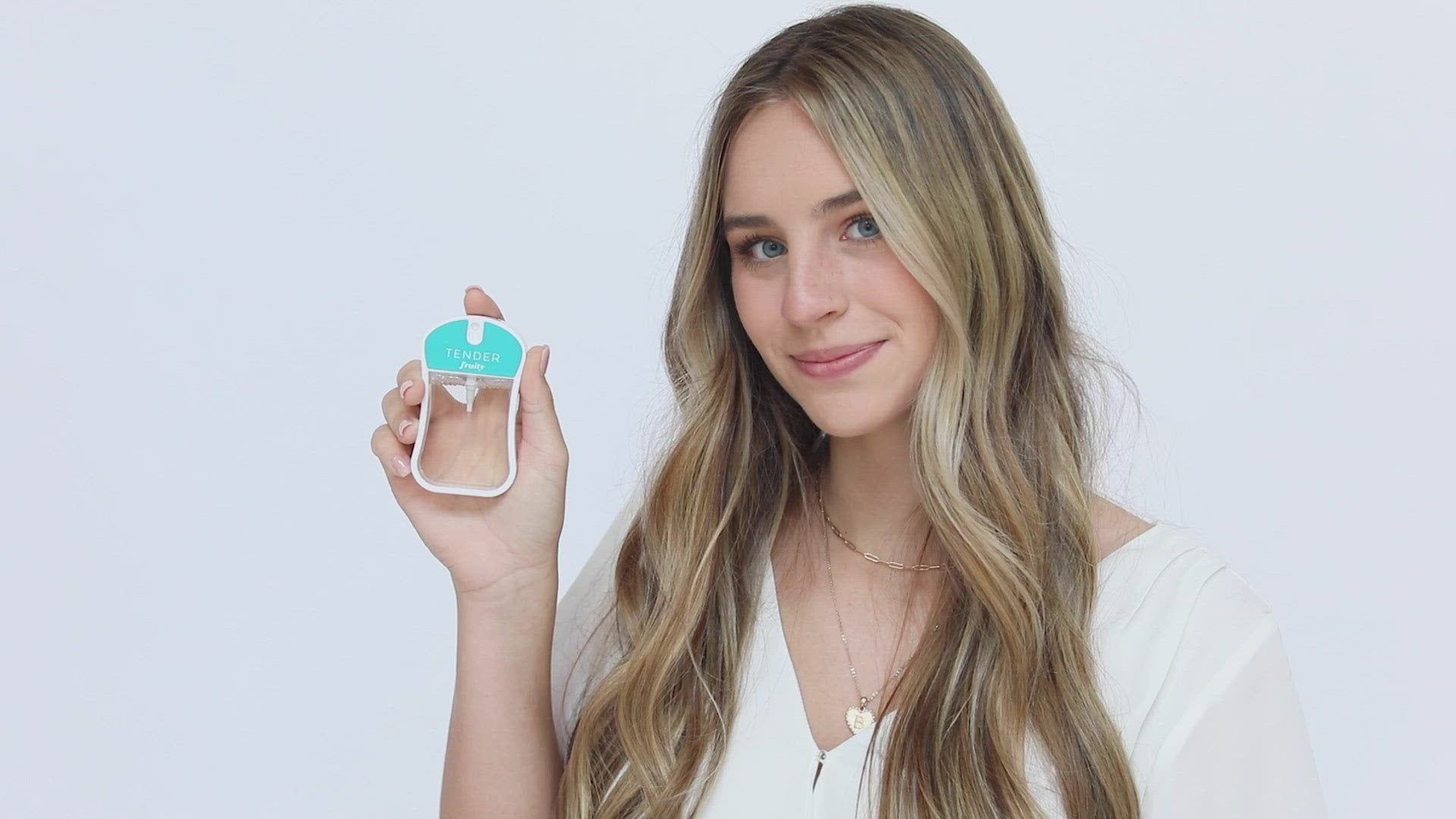 Tender (Fruity) Moisturizing Body Mist in bright blue color box and rounded rectangle spray bottle with bright blue color label and clear liquid. Spray bottle has 1.1 fl oz or 35 mL. Spray bottle and box are pictured with model holding spray bottle in her hand and spraying it then smelling it and smiling.