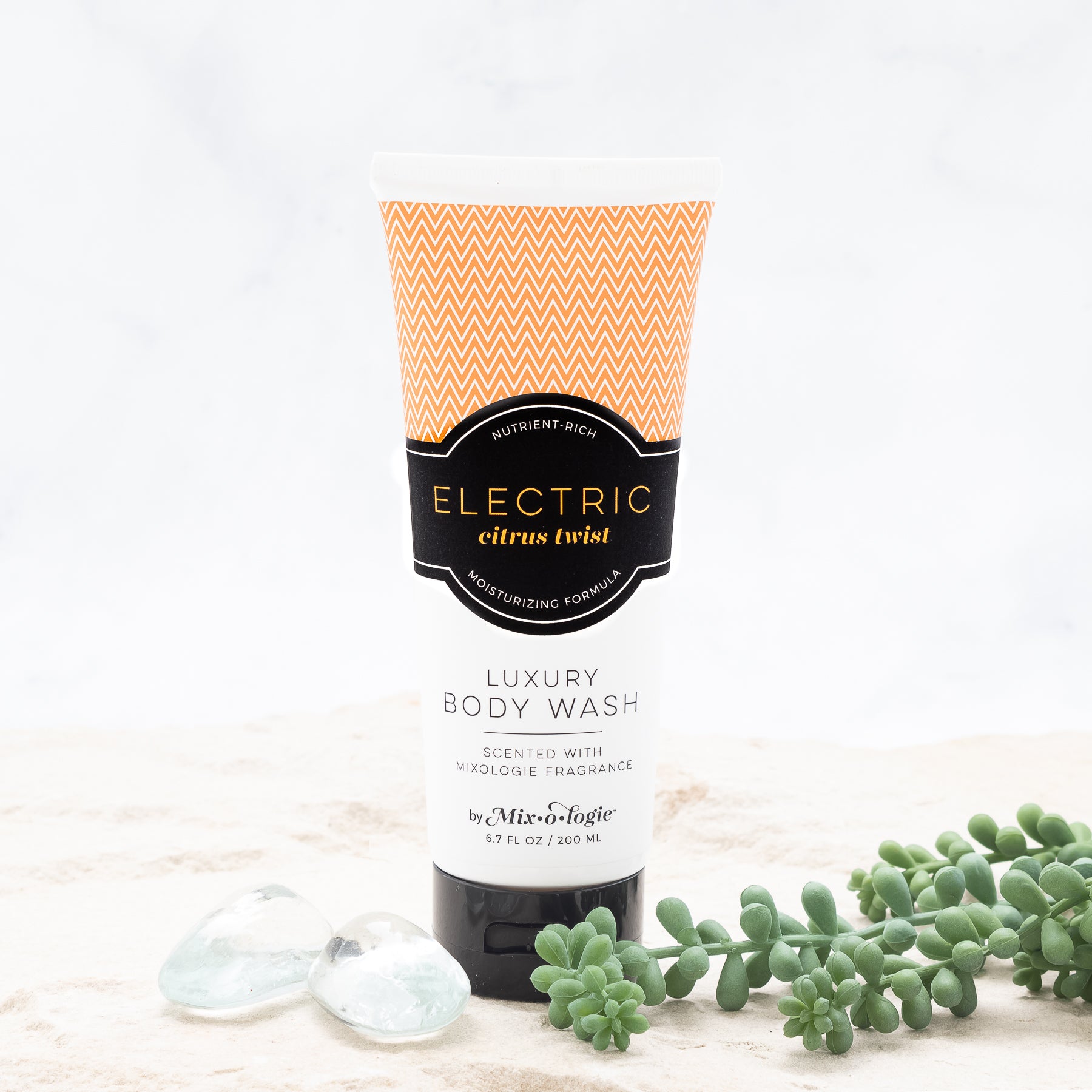 Luxury Body Wash in Mixologie’s Electric (Citrus Twist) in light orange color sample package with black label. Contains 6.7 fl oz or 200 mL pictured on a white background. 