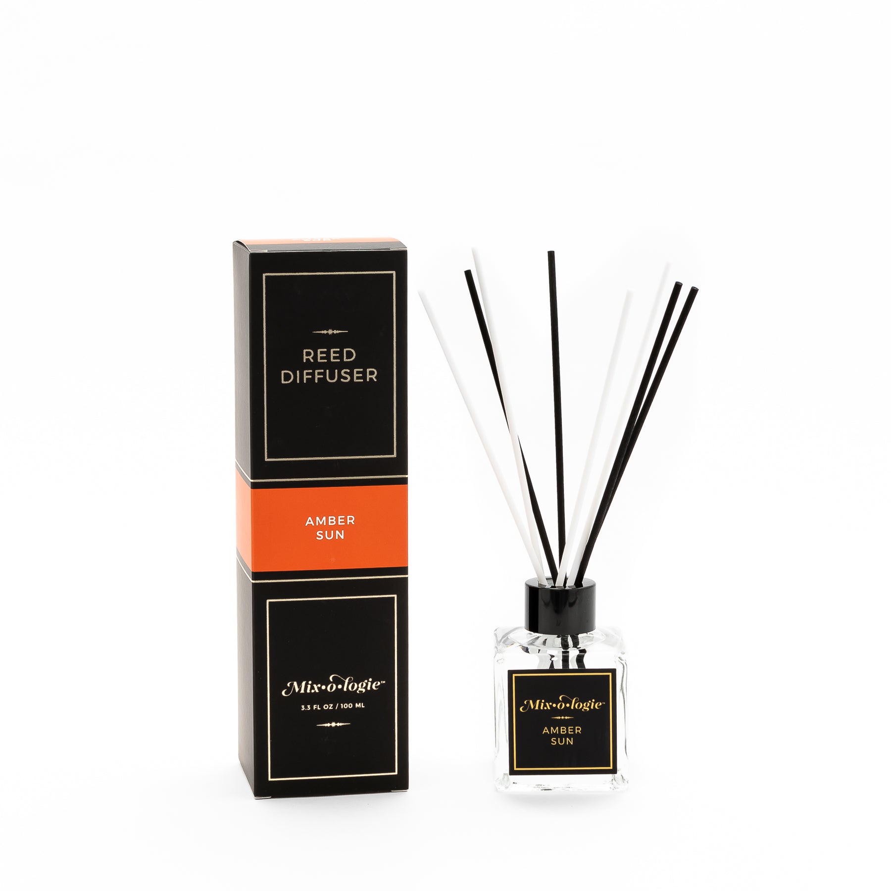 Amber Sun Reed Diffuser is a clear square glass container with black label that says Mixologie – Amber Sun. Has a black top and 4 white & 4 black reed sticks coming out of top, is 3.3 fl oz or 100 mL of clear scented liquid. Black rectangle package box with orange label. Box and diffuser are pictured with white background