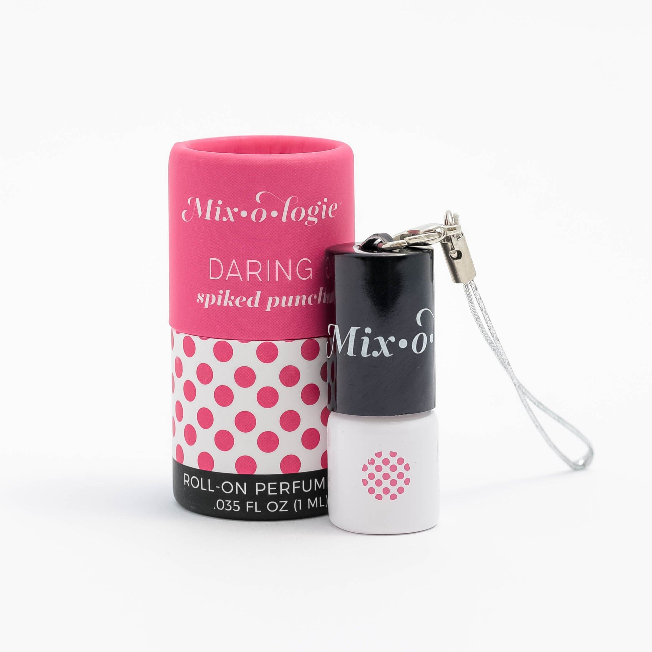 Daring (Spiked Punch) mini white cylinder rollerballs with black top and keychain attachment with bright pink polka dots has .035 fl oz or 1 mL. Bright pink cylinder packing tube with bright pink polka dots. Roll-on perfume oil. Mini rollerball and cylinder tube are pictured on a white background.