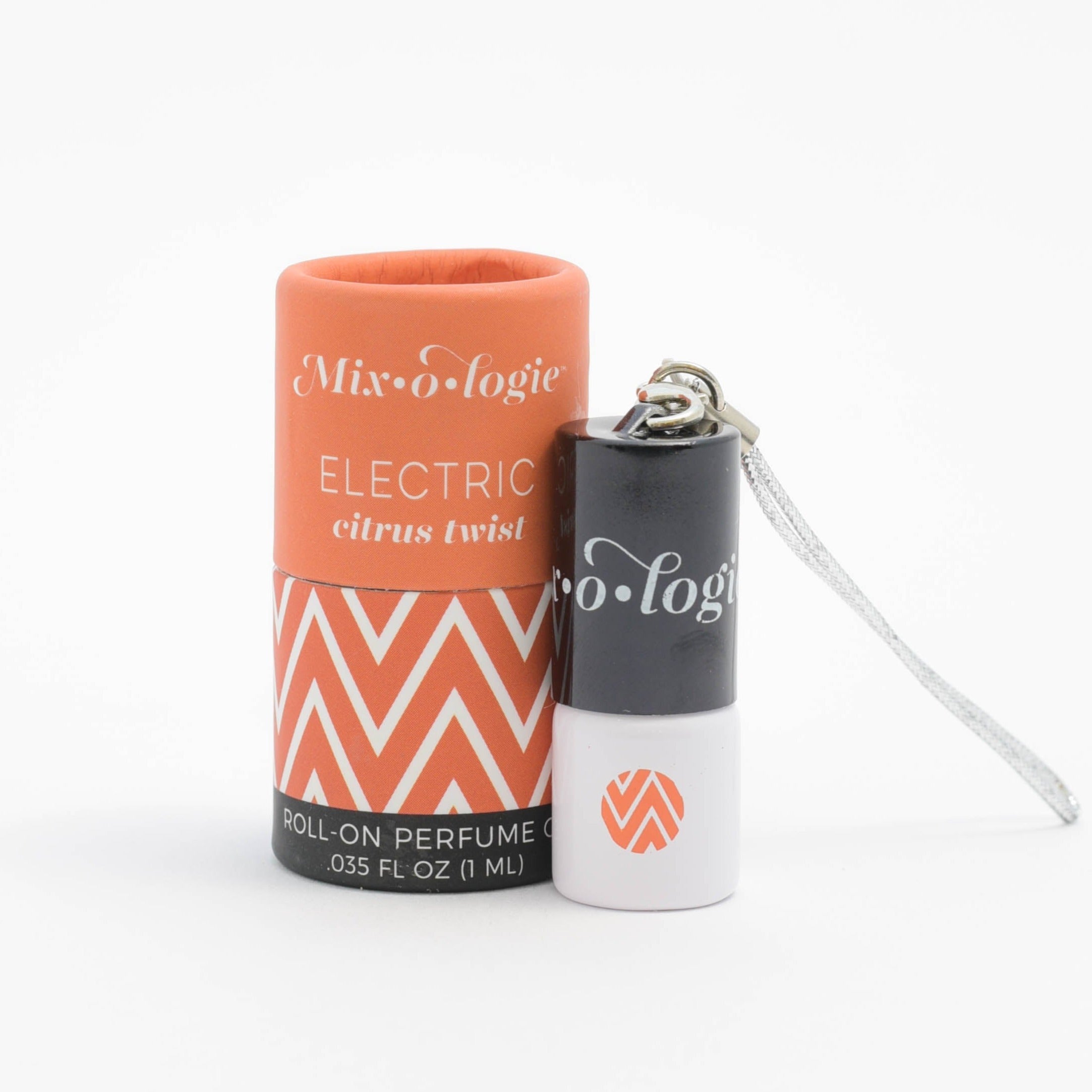 Electric (Citrus Twist) mini white cylinder rollerballs with black top and keychain attachment with orange chevron has .035 fl oz or 1 mL. Orange cylinder packing tube with orange chevron. Roll-on perfume oil. Mini rollerball and cylinder tube are in sand on a white background.