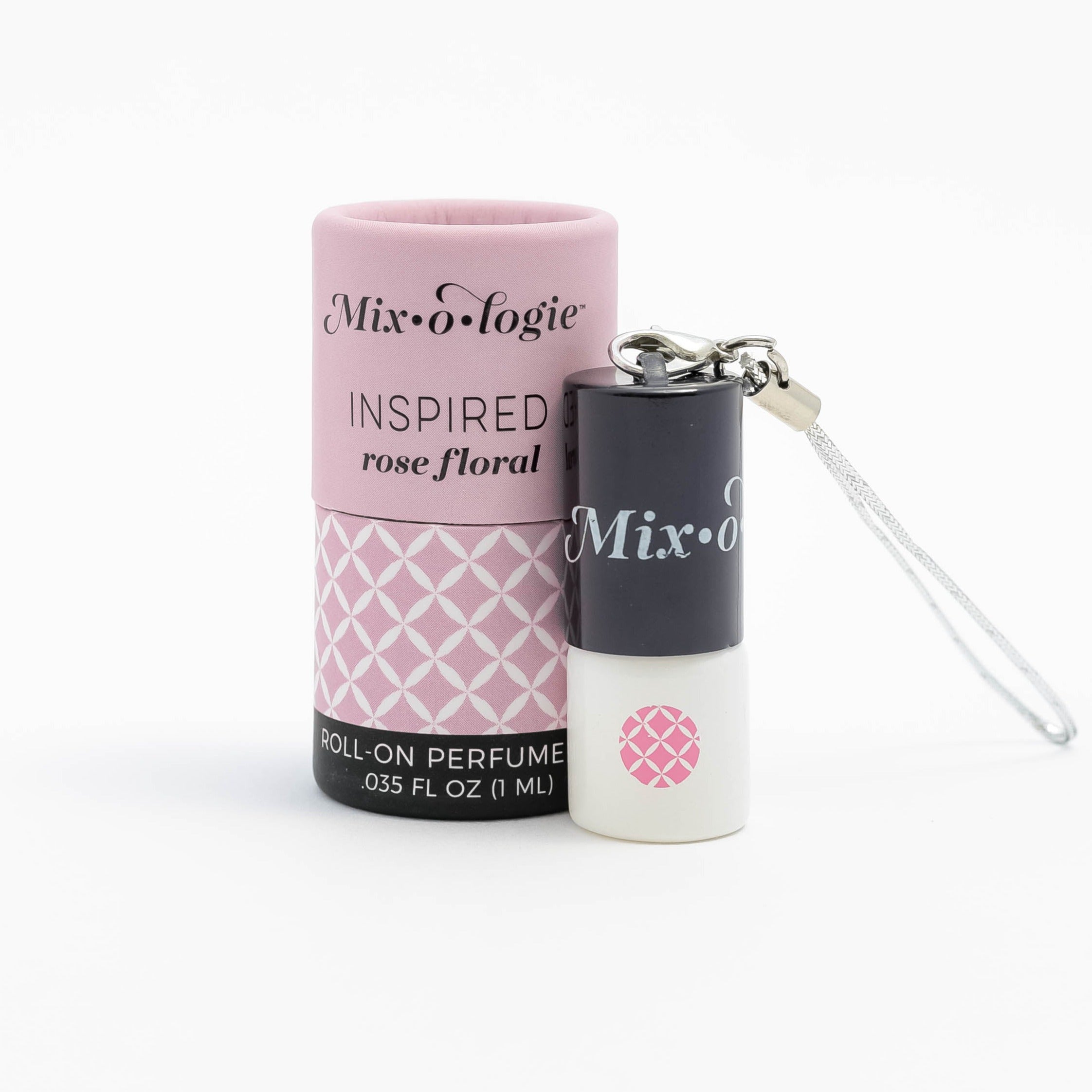 Inspired (Rose Floral) mini white cylinder rollerballs with black top and keychain attachment with pale pink diamond-like pattern and has .035 fl oz or 1 mL. Pale pink cylinder packing tube with pale pink wave-like pattern. Roll-on perfume oil. Mini rollerball and cylinder tube are on a white background.