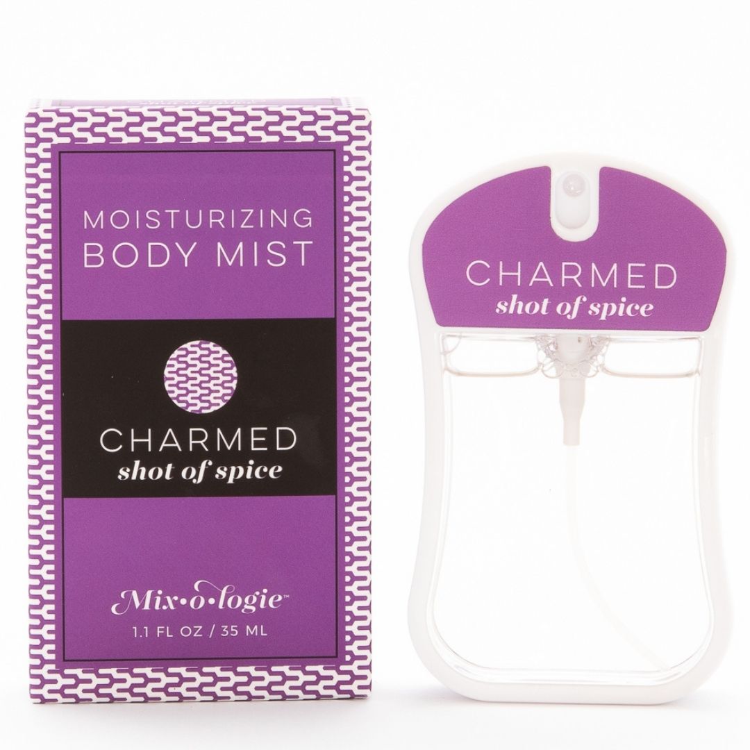 Charmed (Shot of Spice) Moisturizing Body Mist in dark purple color box and rounded rectangle spray bottle with dark purple color label and clear liquid. Spray bottle has 1.1 fl oz or 35 mL. Spray bottle and box are pictured on a white background