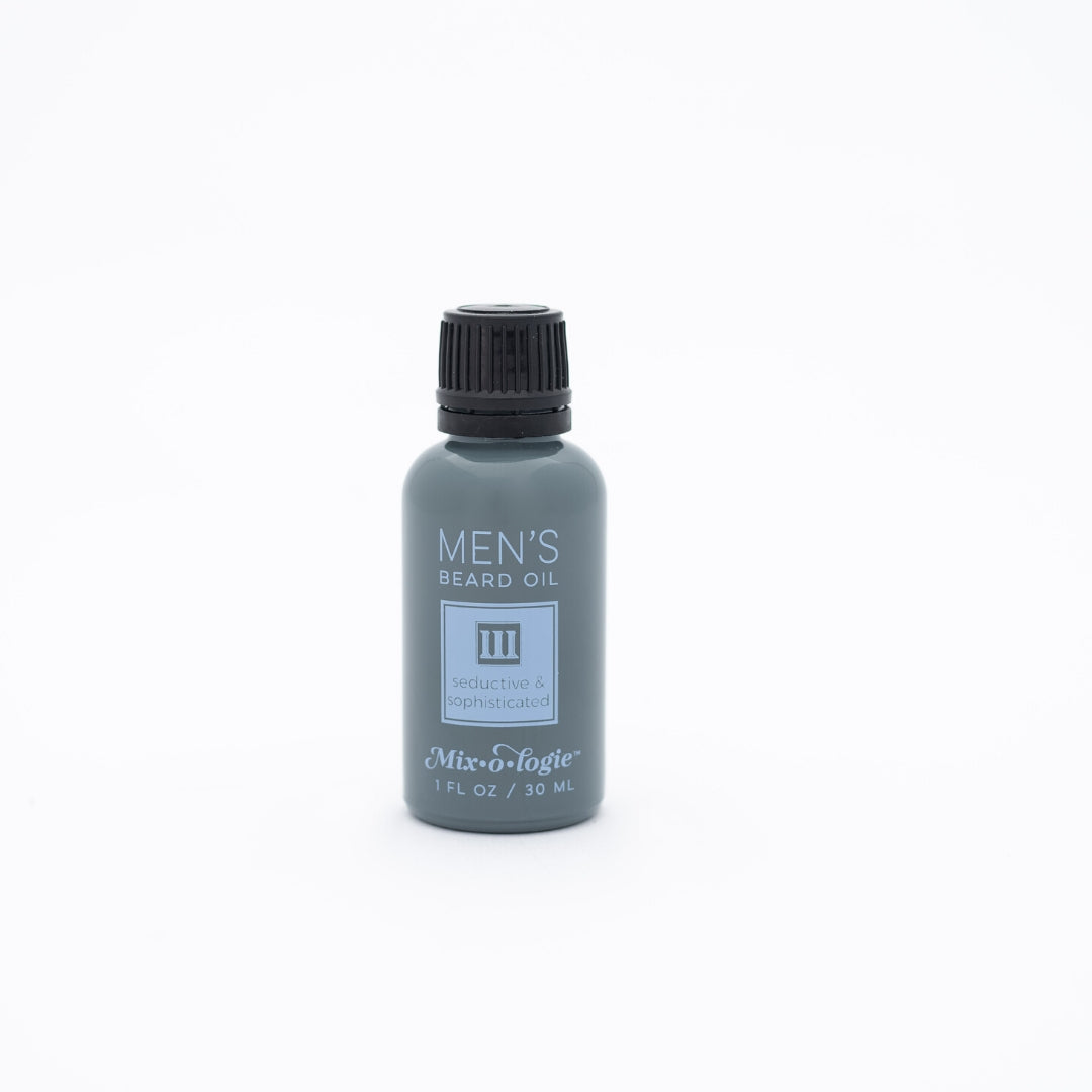 Men’s Beard Oil in Men’s III (Seductive & Sophisticated) in a black and grey bottle with blue colored accents. 1 fl oz or 30 mL. Pictured on white background.