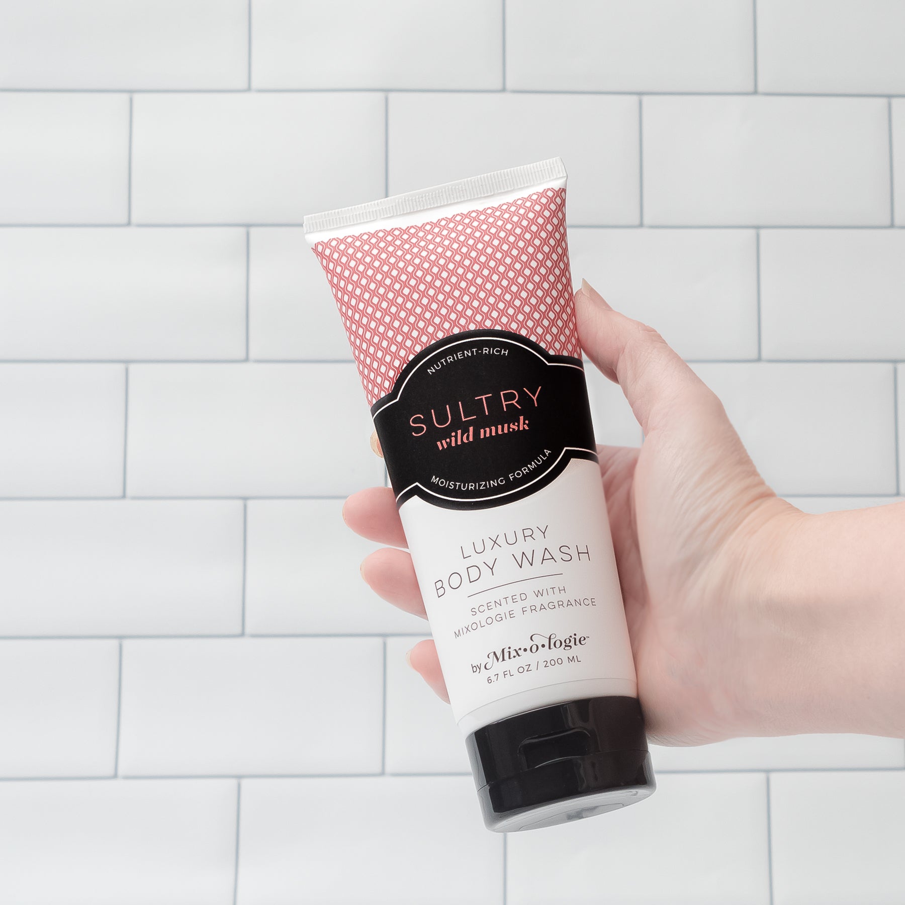 Luxury Body Wash in Mixologie’s Sultry (Wild Musk) in red color sample package with black label. Contains 6.7 fl oz or 200 mL pictured on a white tile background. 