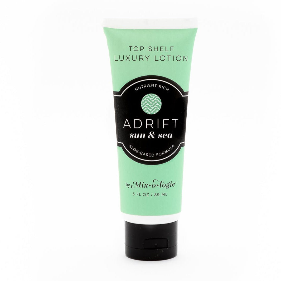 Adrift (Sun & Sea) Top shelf lotion in light green tube with black lid and label. Nutrient rich, aloe based formula, tube has 5 fl oz or 89 mL. Pictured with white background.